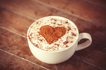 Cup with coffee and shape of the cacao heart on it.