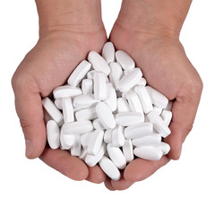 White pills in the hands on a white