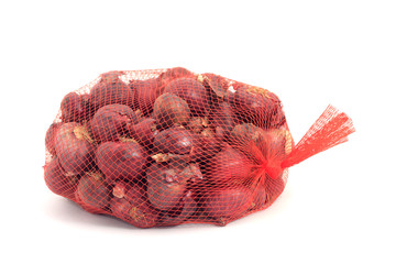 Shallots in a net over white background