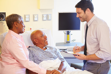 Fototapeta premium Doctor Talking To Senior Couple On Ward