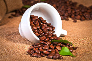 coffee cup and arabica beans on cloth sack