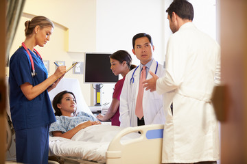 Obraz premium Medical Team Meeting Around Female Patient In Hospital Room