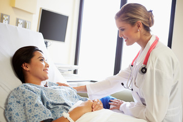 Fototapeta premium Doctor Talking To Female Patient On Ward