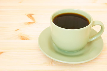 cup of hot coffee on a wooden background