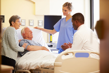 Obraz premium Medical Team Meeting With Senior Couple In Hospital Room