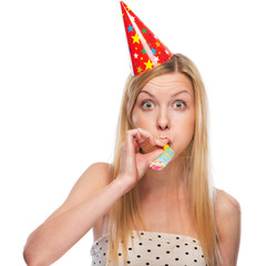 Portrait of teenage girl in cap blowing in party horn blower
