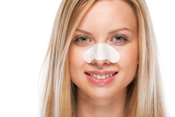 Portrait of smiling teenage girl with clear-up strips on nose