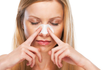 Portrait of teenage girl applying clear-up strips on nose