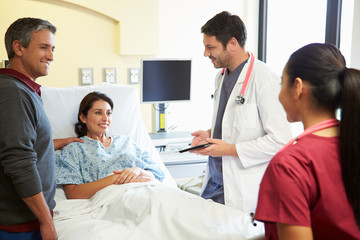 Obraz premium Medical Team Meeting With Couple In Hospital Room