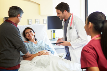 Obraz premium Medical Team Meeting With Couple In Hospital Room