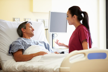 Obraz premium Nurse Talking To Male Patient In Hospital Room