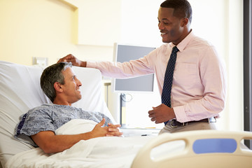 Obraz premium Doctor Talking To Male Patient In Hospital Room