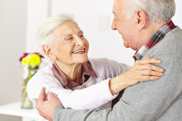 Two senior citizens dancing and smiling