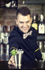 young man working as a bartender in a nightclub bar