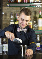 young man working as a bartender in a nightclub bar