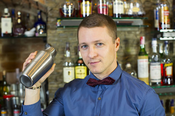 young man working as a bartender in a nightclub bar