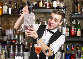 young man working as a bartender in a nightclub bar