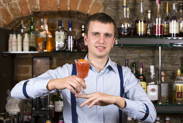 young man working as a bartender in a nightclub bar