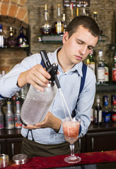 young man working as a bartender in a nightclub bar