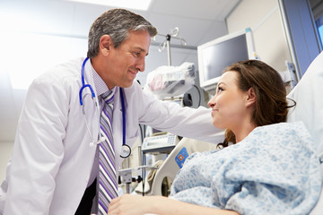 Female Patient Talking To Male Doctor In Emergency Room