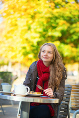 Fototapeta na wymiar Girl eating waffles in a Parisian cafe