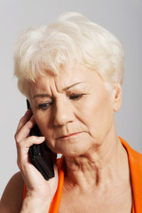 An old lady talking through phone.