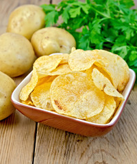 Chips in a bowl with a potato on the board