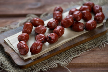Wooden chopping board with freshly made smoked sausages