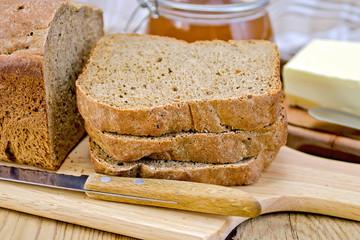 Rye homemade bread stacked with honey and knife