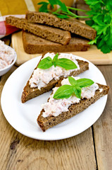 Sandwiches with cream of salmon with bread on the board
