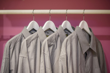 Cloth bar with shirts on curved hangers in wadrobe