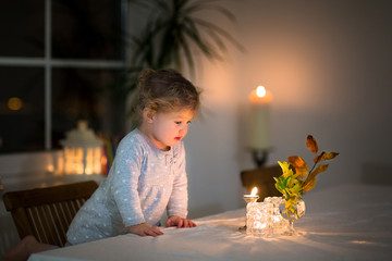 Portrait of a beautiful girl watching candles in a dark room