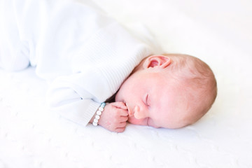 Cute tiny baby sleeping on a knitted blanket