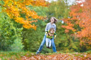 Two kids, a teenager boy and a toddler girl playing together