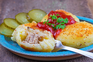 fried potato patties with meat and tomato sauce