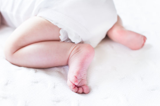 Sweet baby feet on a white knitted blanket