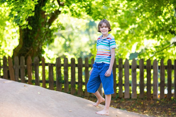 School boy running on a playground on a hot sunny autumn day