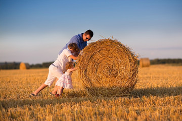 Father and two childrem, a boy and a baby girl, on a field