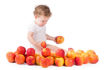 Fototapeta na wymiar Cute baby playing with red apples, on white background