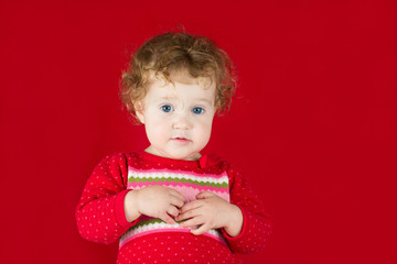 Beautiful girl in a warm knitted sweater on red background