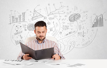 Business man at desk with hand drawn charts