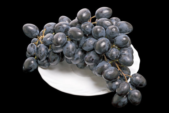 Dark grapes on a white plate