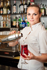 beautiful young barmaid making cocktail
