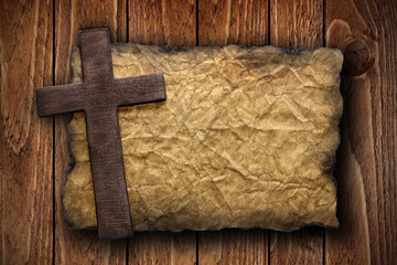 Cross cut out of wood on the old paper
