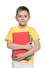 Young boy in yellow shirt with books