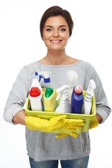 Beautiful  woman in gloves holding different cleaning stuff