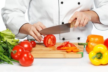 Woman cook cutting vegetables with a sharp knife close-up