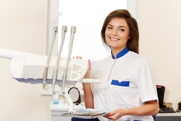 Young woman dentist with dental tools 