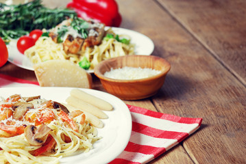 Pasta with shrimps and mashrooms on the wooden table