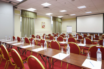 Back of red chairs and wooden tables in stylish room